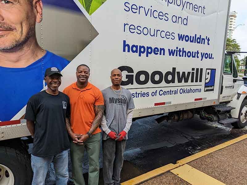 men three in front of moving truck