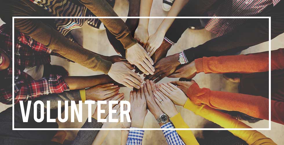 volunteers with their hands together in a circle