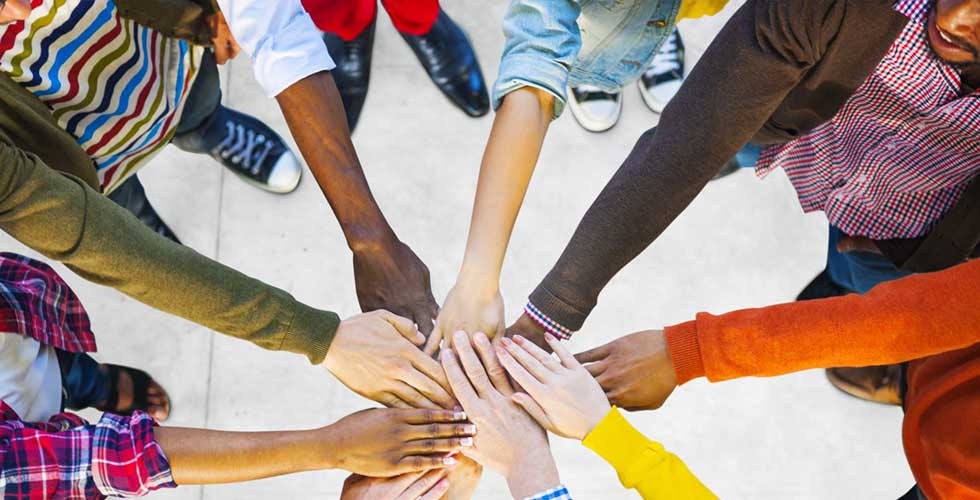 people forming a circle with their hands together in the circle